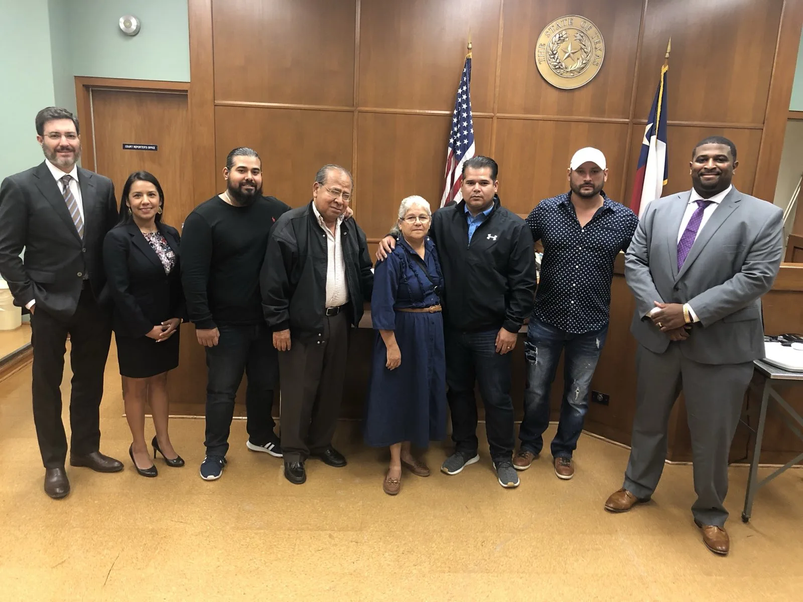 A client’s family standing with the VB Attorneys trial team in a courtroom