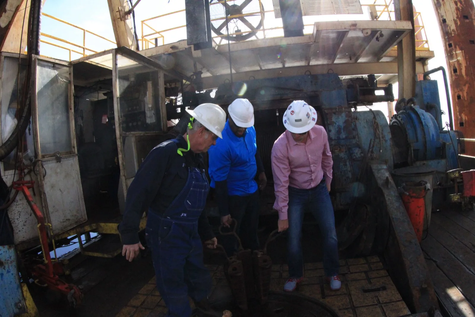 VB Attorneys lawyers in hardhats inspecting drawworks machinery aboard an offshore rig