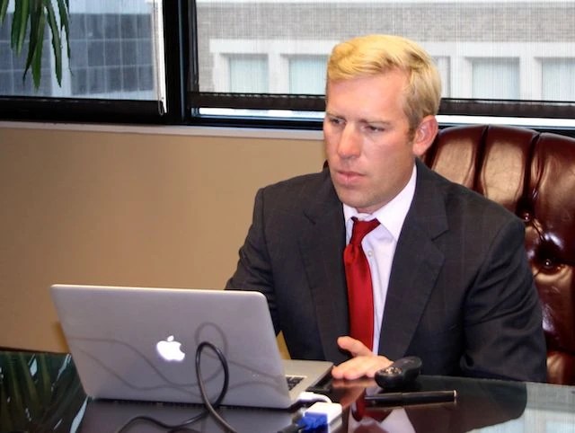 Brian Beckcom working at a laptop at a conference table.
