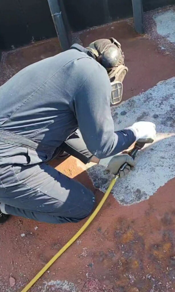 Mariner Najee wearing protective gear while performing maintenance work on a vessel’s steel surface.