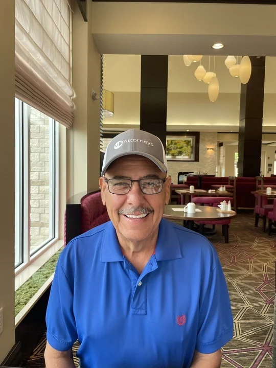 Benito V. smiling in a blue polo and VB Attorneys cap.