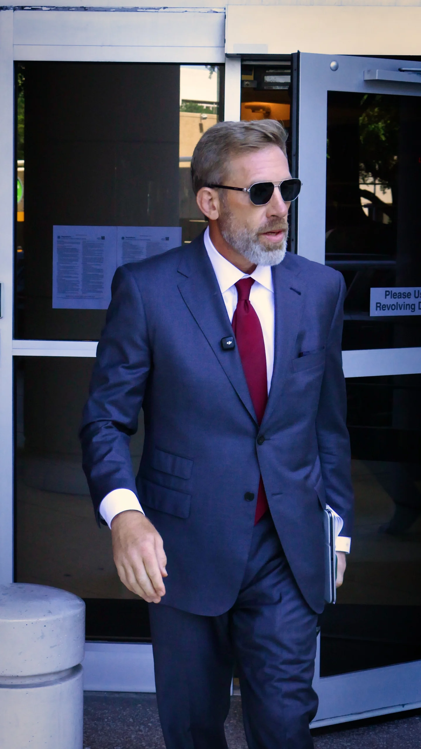 Brian Beckcom at a courthouse entrance carrying case materials