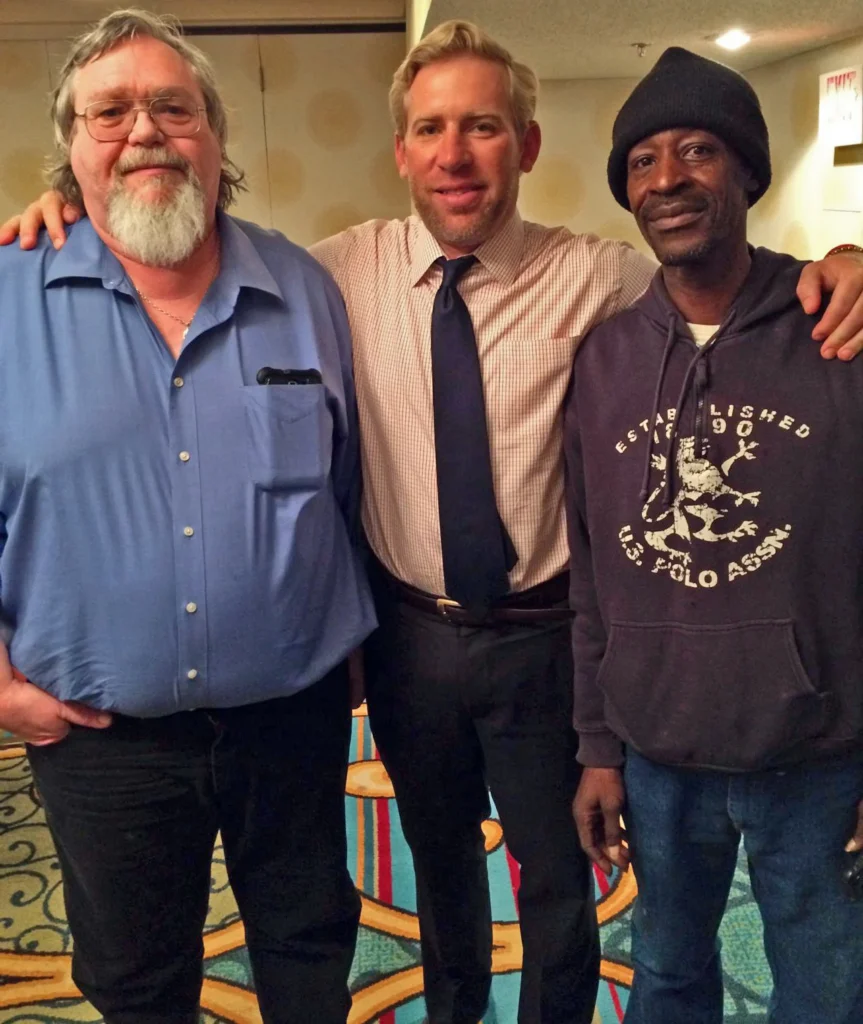 Brian Beckcom stands between two Maersk Alabama crew clients.
