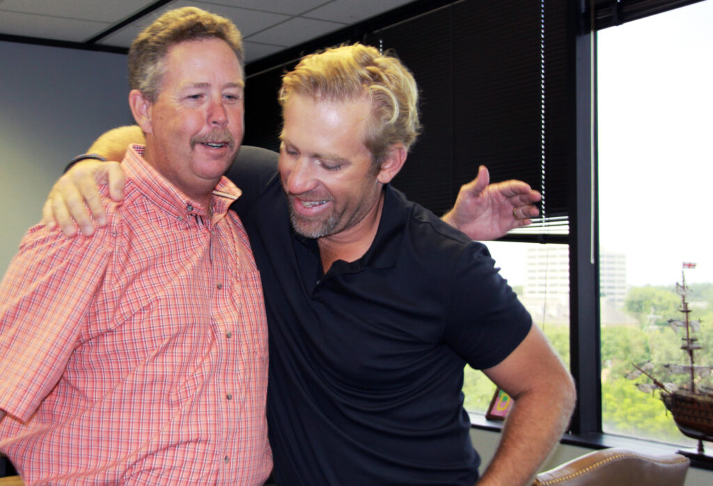 Oilfield specialist Don O. and attorney Brian Beckcom embracing.