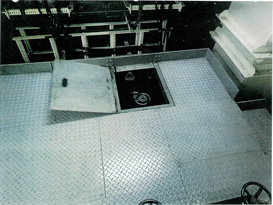 Open deck access panel with a valve handwheel below the floor.
