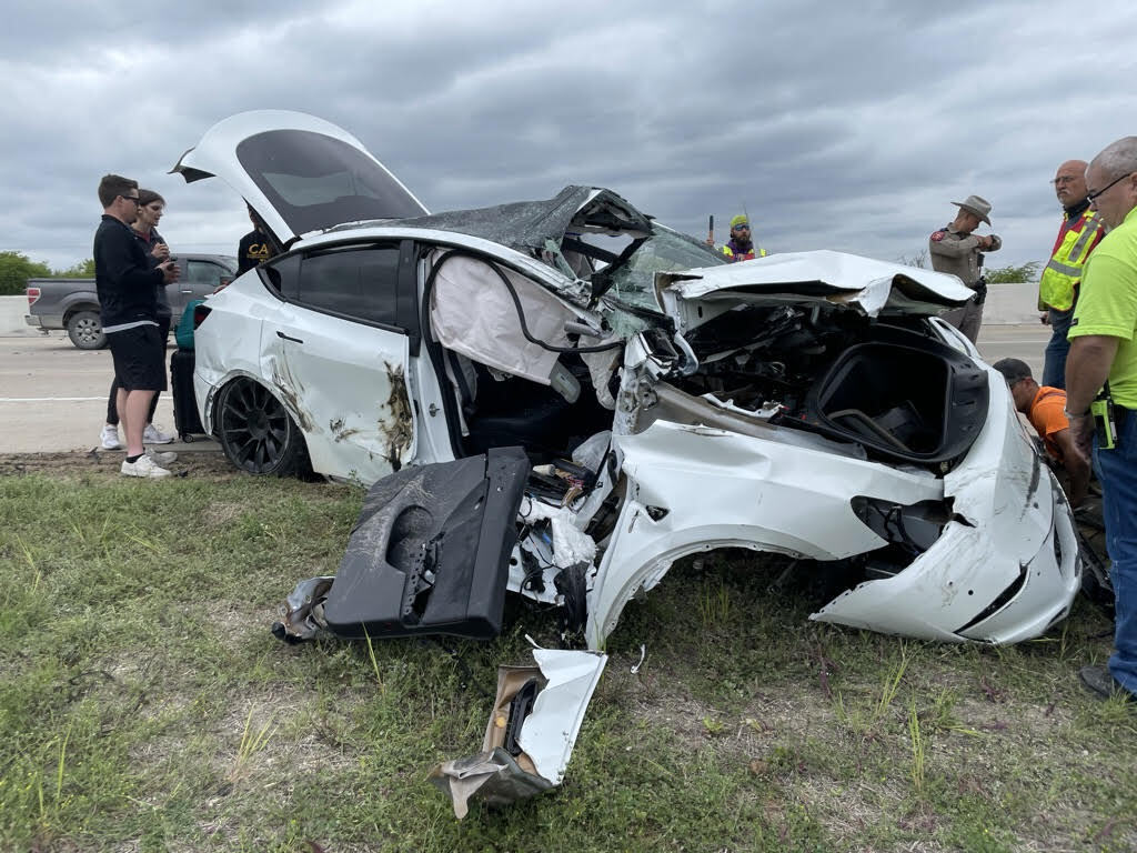 The McClendons’ damaged white Tesla at the roadside after the crash.