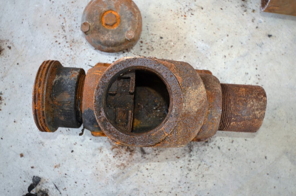 Interior of a removed valve body with its detached cap beside it during inspection.